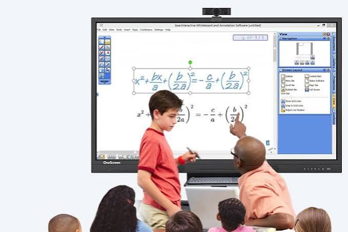 teacher explaining to student, beside a smart board